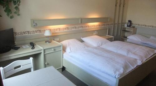 博克讷姆克内普酒店的一间卧室配有一张床和一张书桌及电视