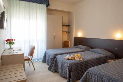 佛罗伦萨AUTO PARK Hotel的酒店客房,设有两张床和一张桌子,上面有食物