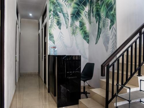 TelukjambeOYO Life 3251 D'daun Inn的走廊上设有棕榈树壁画的楼梯
