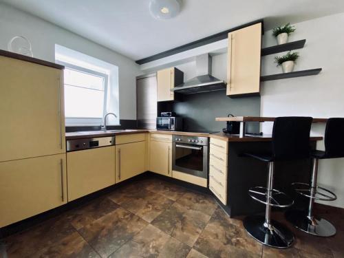 齐尔Luxuriöses und modernes Apartment zum Wohlfühlen的厨房配有木制橱柜和桌椅
