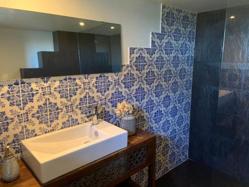加亚新城多罗码头一室公寓的浴室设有白色水槽和蓝色瓷砖