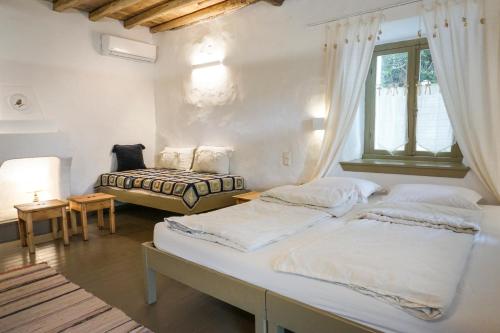 达默查理Ghermaniko Guesthouse的一间卧室设有两张床和窗户。