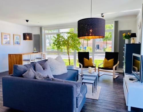伯尔格伦德-雷特维施Appartement-Boergerende的客厅配有蓝色的沙发和电视