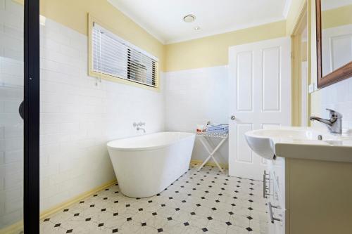 波特兰Clifftop Apartments Portland Vic的白色的浴室设有浴缸和水槽。