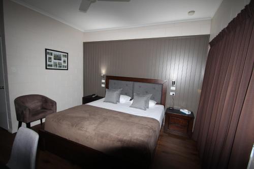 汤斯维尔殖民玫瑰汽车旅馆的配有一张床和一把椅子的酒店客房