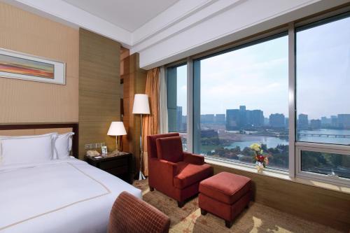 南京Crowne Plaza Nanjing Jiangning, an IHG Hotel的酒店的客房 - 带一张床、椅子和窗户