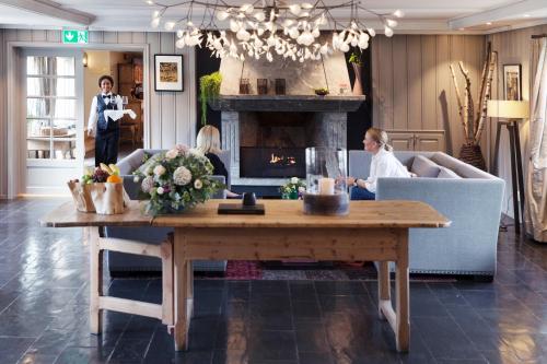 奥斯陆历史酒店的客厅配有桌子和壁炉