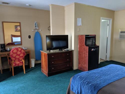 Glennville格伦维尔奇瑞奥酒店的酒店客房设有一间带一张床和电视的卧室