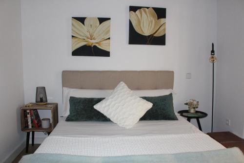 托莱多La Casa Toledana Estudio - Patio y Artesonado的卧室配有带绿色枕头的白色床