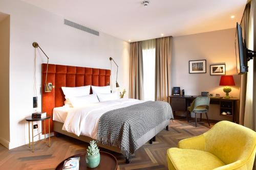 弗伦斯堡Das James的配有一张床和一把椅子的酒店客房