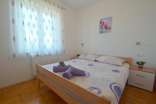 奇茲希Apartment Baran的一间卧室配有一张带紫色毛巾的床