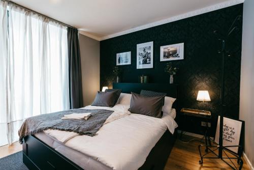 格拉茨Luxury Downtown Appartement mit Garage的一间卧室设有一张大床和黑色墙壁