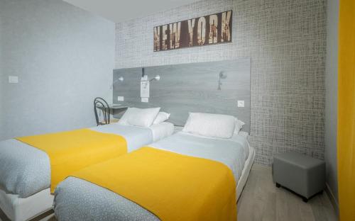 普瓦捷马克床酒店的黄色和白色的客房内的两张床