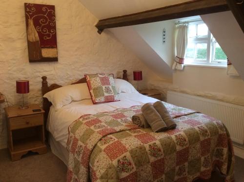 ChideockChiddy Nook Cottage的一间卧室配有一张带被子的床和一扇窗户