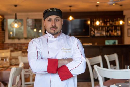 普罗夫迪夫PULPUDEVA Family Hotel的站在餐厅的厨师,手臂交叉