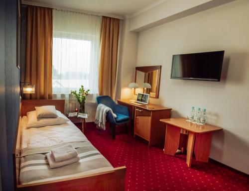 普热梅希尔信天翁酒店的酒店客房配有一张床、一张书桌和一台电视。