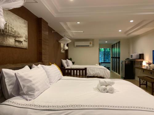 坤西育府Namtok Sarika Resotel的酒店客房,配有两张带毛巾的床