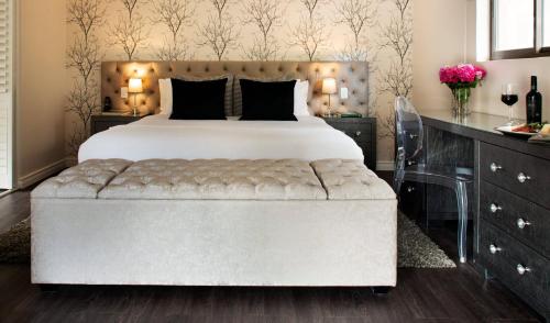斯泰伦博斯Alluvia Boutique Winery & Luxury Accommodation的一间卧室配有一张大床和软垫床头板