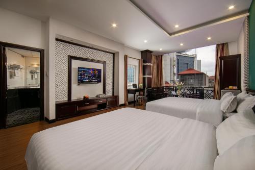 河内ĐỨC TRỌNG HOTEL的酒店客房设有两张床和一个阳台。