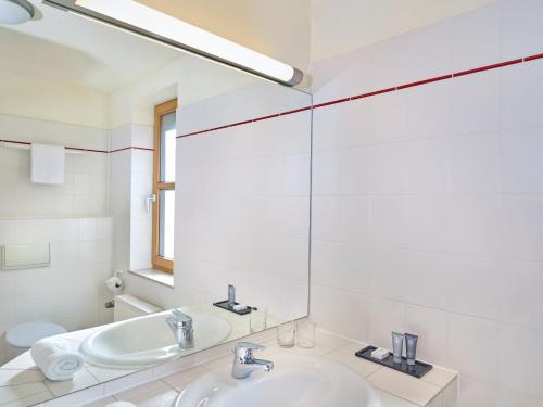 布劳恩拉格Hapimag Ferienwohnungen Braunlage的白色的浴室设有两个盥洗盆和镜子