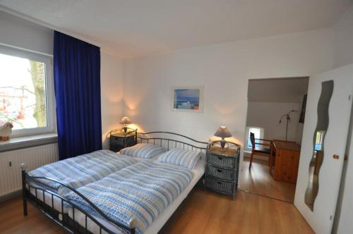 吕贝克Ferienwohnungen Abraham的一间卧室配有一张带蓝色棉被的床和窗户。