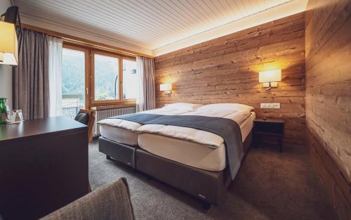 达沃斯Hotel Strela by Mountain Hotels的卧室配有一张木墙内的大床