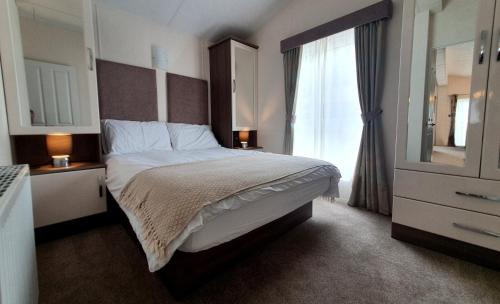 基督城Sea Shore Lodge Mudeford的一间卧室设有一张大床和一个窗户。