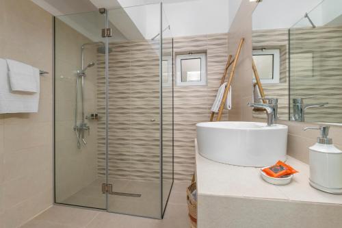 罗达奇诺V&C Paradise Apartments的一间带玻璃淋浴和水槽的浴室