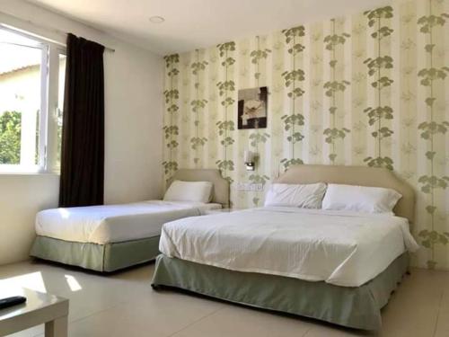 关丹Summer Green Lodge的一间卧室设有两张床和窗户。