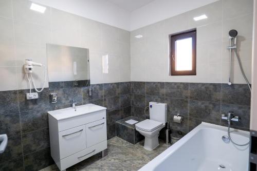 布加勒斯特Hotel Simona的带浴缸、卫生间和盥洗盆的浴室