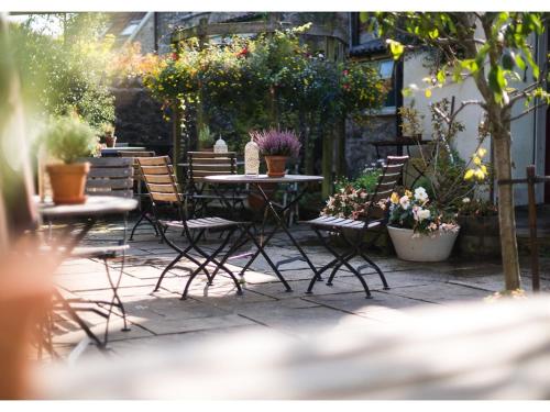 谢普顿马利特萃峰旅馆的庭院设有桌椅,种植了植物和鲜花