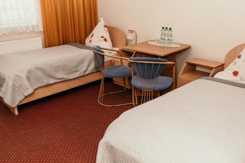 奥斯亚科拉苏施汽车旅馆的酒店客房带一张床、一张桌子和椅子