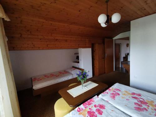 博希尼Apartment Žvab的一间设有两张床的房间和一张鲜花桌子