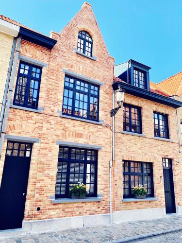 布鲁日B&B Marie-J of Bruges的街道上带黑窗的砖砌建筑