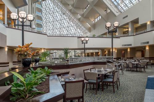 布里奇顿Crowne Plaza Hotel St. Louis Airport, an IHG Hotel的大楼内带桌椅的用餐室