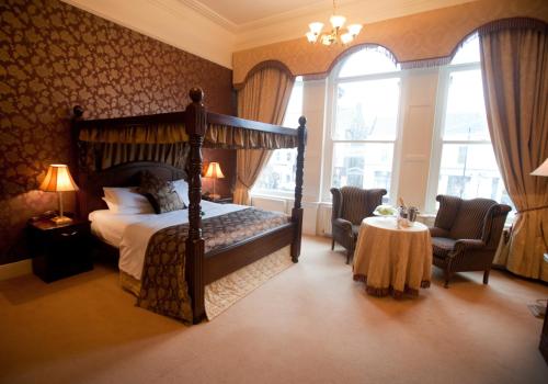 莫纳汉维斯特纳阿姆斯酒店的一间卧室配有一张床和一张桌子及椅子