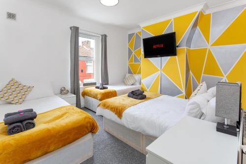 利物浦The World Famous Henderson House FREE PARKING的一间卧室设有两张床,墙上配有电视。