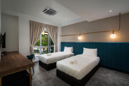 北赖Masson Hotel Butterworth的酒店客房配有两张床和一张书桌