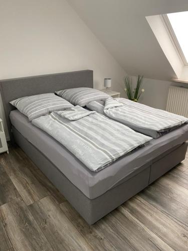 诺特海姆Apartments Benzweg 2的铺有木地板的白色卧室内的一张床位