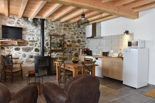 SiguerGite du Carbounet et la Grange de Lou的厨房配有白色冰箱、桌子和椅子