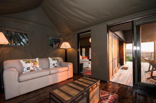 阿马卡拉保护区HillsNek Safari Camp – Amakhala Game Reserve的客厅配有沙发和桌子