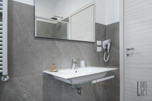 代森扎诺-德尔加达Du Lac Aparments的浴室设有白色水槽和镜子