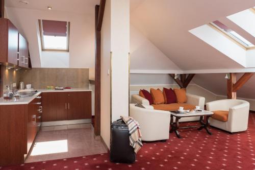克拉科夫Booking Hotel Crown Piast & Spa的厨房以及带沙发和桌子的客厅。