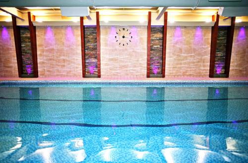肯德尔Castle Green Hotel In Kendal, BW Premier Collection的墙上有一个钟表的游泳池