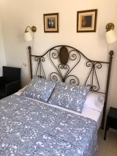 洛斯克里斯蒂亚诺斯Apartment Cardon Los Cristianos的一张带蓝色毯子的床和墙上的两张照片