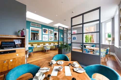 贝辛斯托克奥克利霍尔酒店的一间带桌子和蓝色椅子的用餐室