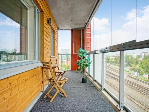 奥卢奥卢家居庭公寓的阳台配有两把椅子和植物