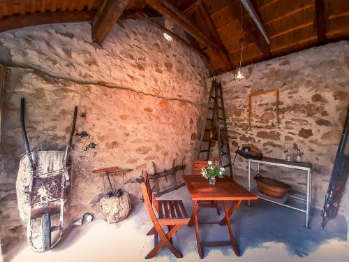 包道乔尼托毛伊Wild Boar Cottage - Romantic getaway的石墙内的房间,配有桌椅