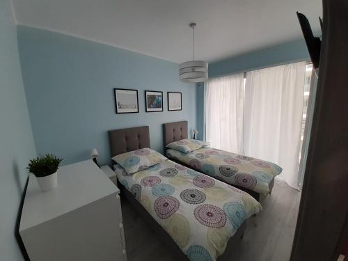 米兹多洛杰Apartament Aniutka的一间卧室设有两张床、一张桌子和一个窗口。