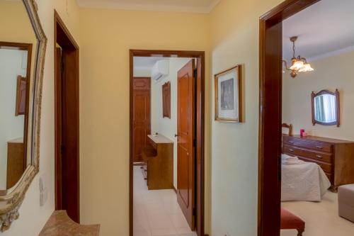 奎特里拉Apartamento São Pedro do Mar的走廊通往带1张床和镜子的卧室